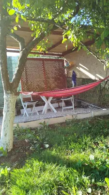 a hammock and two chairs under a tree at Pyramid Gardens in Visoko