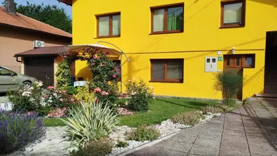 a yellow house with a garden in front of it at Pyramid Gardens in Visoko