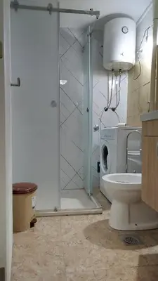 a bathroom with a toilet and a glass shower at Pyramid Gardens in Visoko