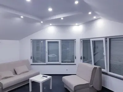 a living room with a couch and a table and windows at apartman Dani in Derventa