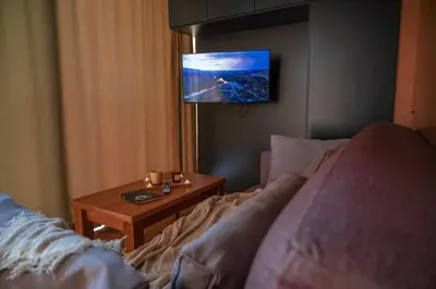 a living room with a couch and a tv at Waterfall Glamping Cabin in Bihać