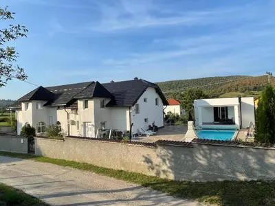 a house with a swimming pool next to a wall at Villa Sami in Bihać