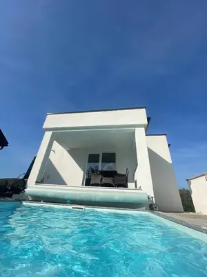 a swimming pool in front of a house at Villa Sami in Bihać