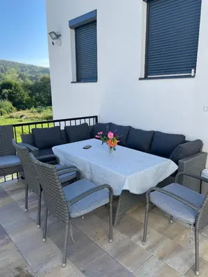 a table with chairs and a blue couch on a patio at Villa Sami in Bihać