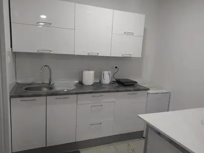 a white kitchen with a sink and white cabinets at Apartman Markešić 3 in Ripci