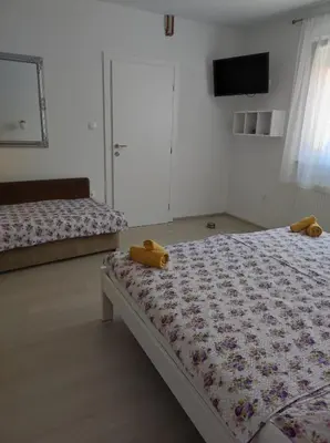 a bedroom with a bed with a teddy bear on it at Apartman Markešić 3 in Ripci