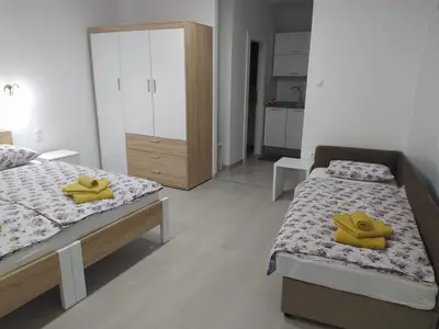 a bedroom with two beds with yellow towels on them at Apartman Markešić 3 in Ripci