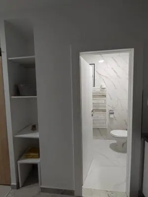 a white bathroom with a toilet and a shower at Apartman Markešić 3 in Ripci
