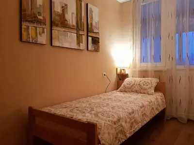 a bedroom with a bed and a lamp and a window at Apartman Radjenovic in Banja Luka