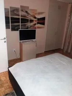 a bedroom with a bed and a flat screen tv at Apartman Radjenovic in Banja Luka