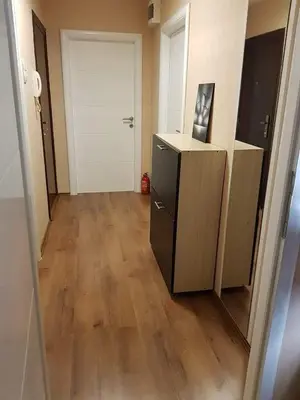 a hallway with a white door and a wooden floor at Apartman Radjenovic in Banja Luka