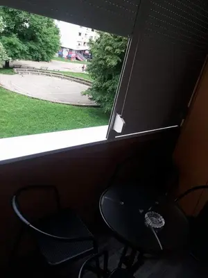 a window with a table and two chairs in a room at Apartman Radjenovic in Banja Luka