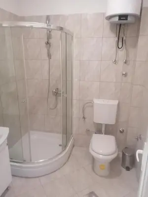 a bathroom with a shower and a toilet and a sink at Sphinx Apartment in Visoko