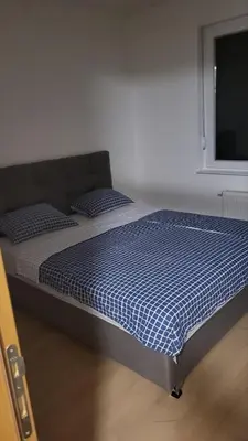 a bed in a room with a blue comforter at Apartman Paradiso in Banja Luka