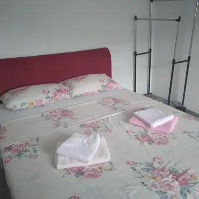 a bed with two pillows and towels on it at Iva apartmani in Jajce