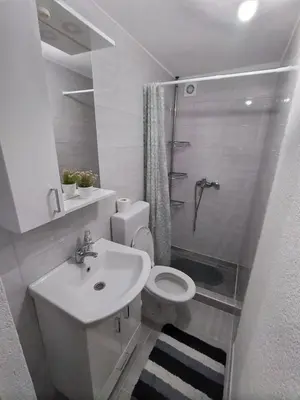 a bathroom with a toilet and a sink and a shower at Iva apartmani in Jajce
