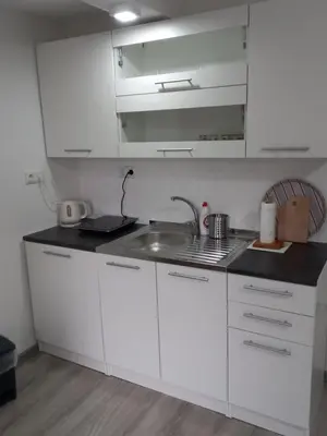 a kitchen with white cabinets and a sink at Iva apartmani in Jajce
