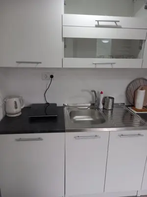 a white kitchen with a sink and a counter top at Iva apartmani in Jajce