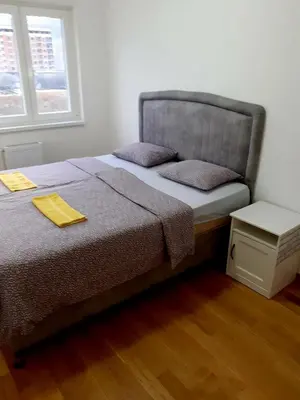 a bedroom with a bed with a yellow napkin on it at Apartman kod Brke 20 A Bulevar Vojvode Živojina Mišiča in Banja Luka