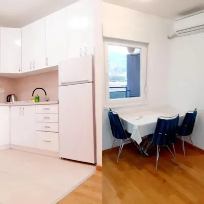 a white kitchen with a table and blue chairs at Apartman kod Brke 20 A Bulevar Vojvode Živojina Mišiča in Banja Luka