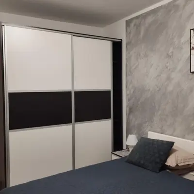 a bedroom with white and black walls and a bed at Little Paradise in Bihać