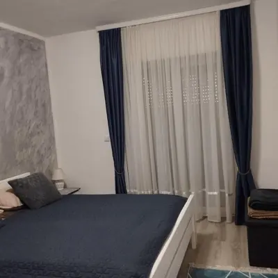 a bedroom with a bed and a window with curtains at Little Paradise in Bihać