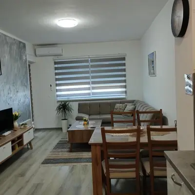 a living room with a couch and a table and chairs at Little Paradise in Bihać