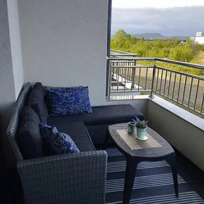 a couch and a coffee table on a balcony at Little Paradise in Bihać