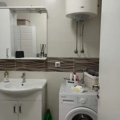 a bathroom with a sink and a washing machine at Little Paradise in Bihać