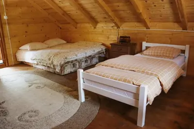 a bedroom with two beds in a wooden cabin at Apartmani Kajkut in Banja Luka