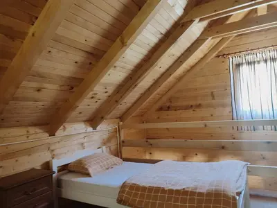 a bedroom in a log cabin with a bed at Apartmani Kajkut in Banja Luka