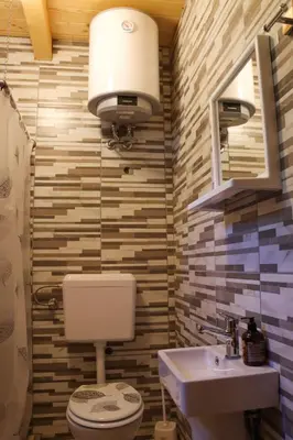 a bathroom with a toilet and a sink and a light at Apartmani Kajkut in Banja Luka