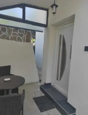 a room with a door and a table and a table and chair at Ajsha Guesthouse in Jajce