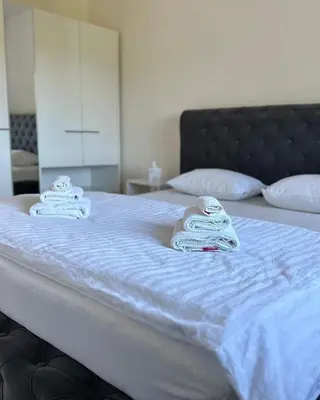 a white bed with towels on top of it at Hotel Pilot in Cazin