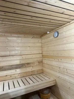 a wooden sauna with a clock on the wall at Hotel Pilot in Cazin