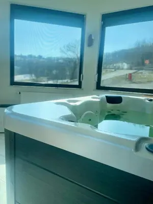 a white sink in a bathroom with two windows at Hotel Pilot in Cazin