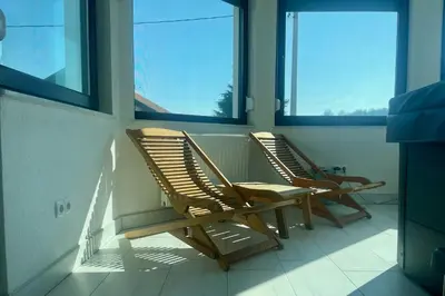 two rocking chairs on a balcony with windows at Hotel Pilot in Cazin
