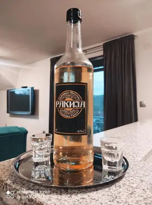 a bottle of beer sitting on a table with two glasses at Apartman-vikendica Mihajlović in Banja Luka
