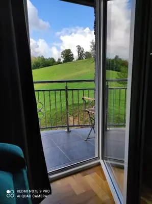 a view from a sliding glass door looking out at a field at Apartman-vikendica Mihajlović in Banja Luka