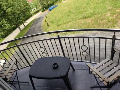 a balcony with a table and a bench and a street at Apartman-vikendica Mihajlović in Banja Luka
