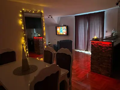 a room with a table and chairs and a television at Apartman-vikendica Mihajlović in Banja Luka