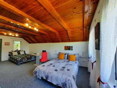 a bedroom with a bed and a couch and wooden ceilings at Ravne Konak in Visoko