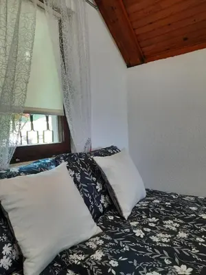 a bedroom with a bed with pillows and a window at Ravne Konak in Visoko