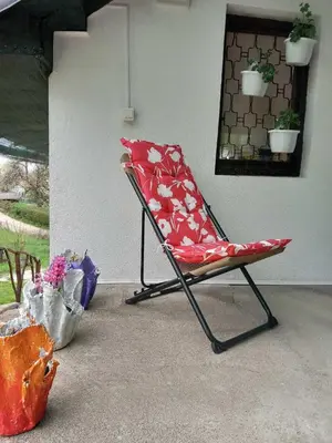 a red chair sitting in a living room at Ravne Konak in Visoko