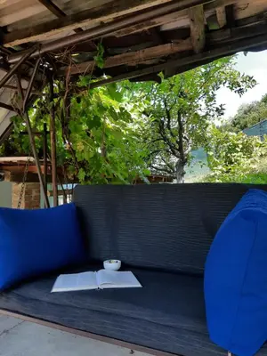 a blue couch with a book and a cup on it at Ravne Konak in Visoko