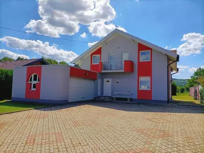 a red and white house with a garage at Haus mit großen Garten in Modriča