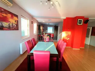 a dining room with a table and pink chairs at Haus mit großen Garten in Modriča