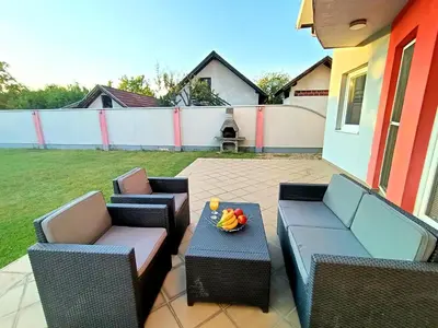 a patio with chairs and a table with a bowl on it at Haus mit großen Garten in Modriča