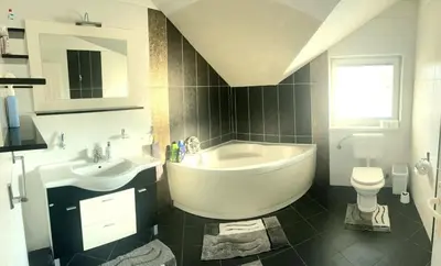a bathroom with a tub and a sink and a toilet at Haus mit großen Garten in Modriča
