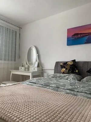 a bedroom with a large bed and a mirror at Apartman Nova Varos in Banja Luka